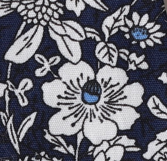 Detalle tejido corbata de lazo azul marino con flores