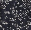 Detalle tejido corbata de lazo gris con flores blancas